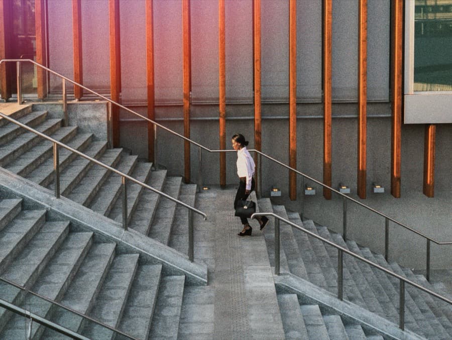 A business professional moving through a modern office setting.
